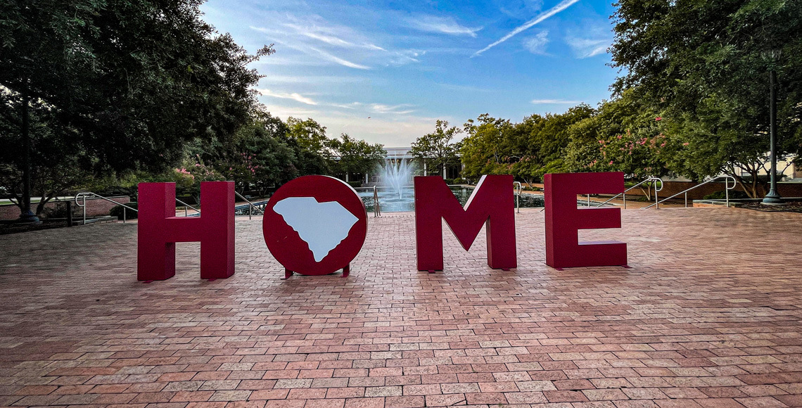 Large letters in garnet spelling out the word HOME, highlight the front of the fountain and entrance to the library