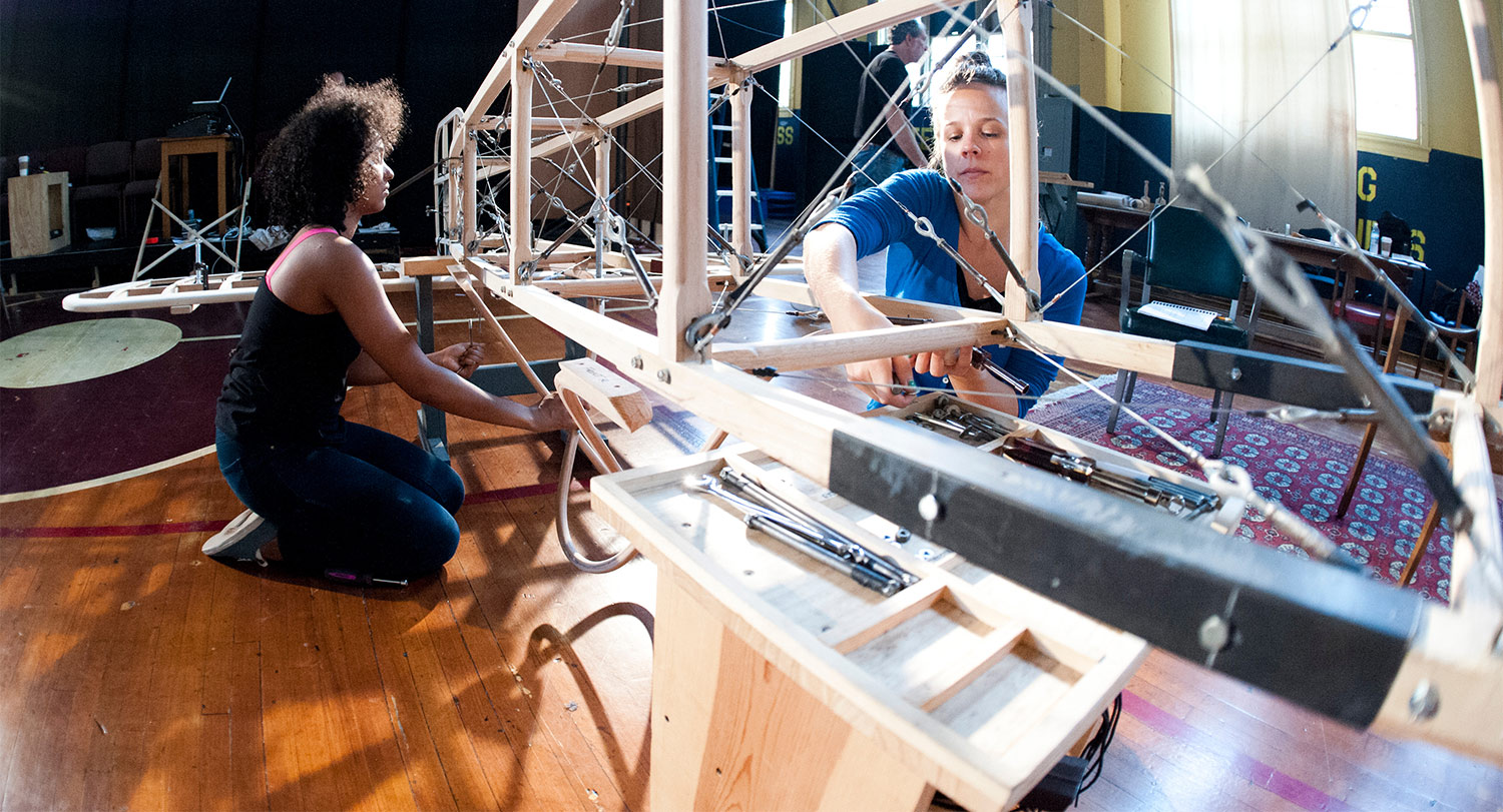 Students building wooden and metal frame for a theatre set.