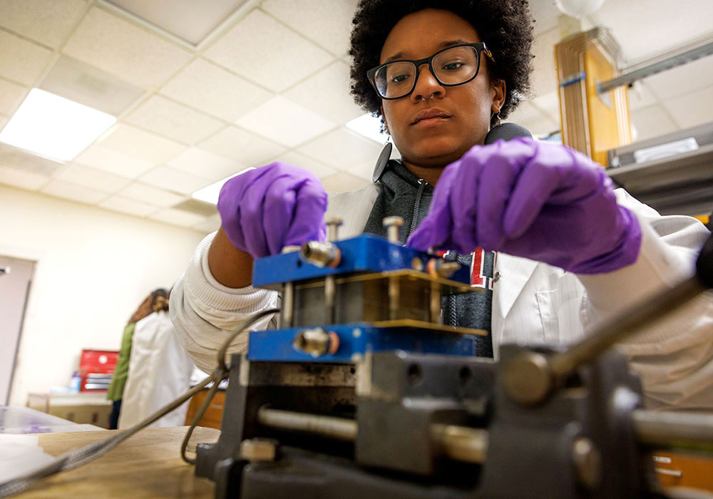 Student working with an electrical piece of equipment.