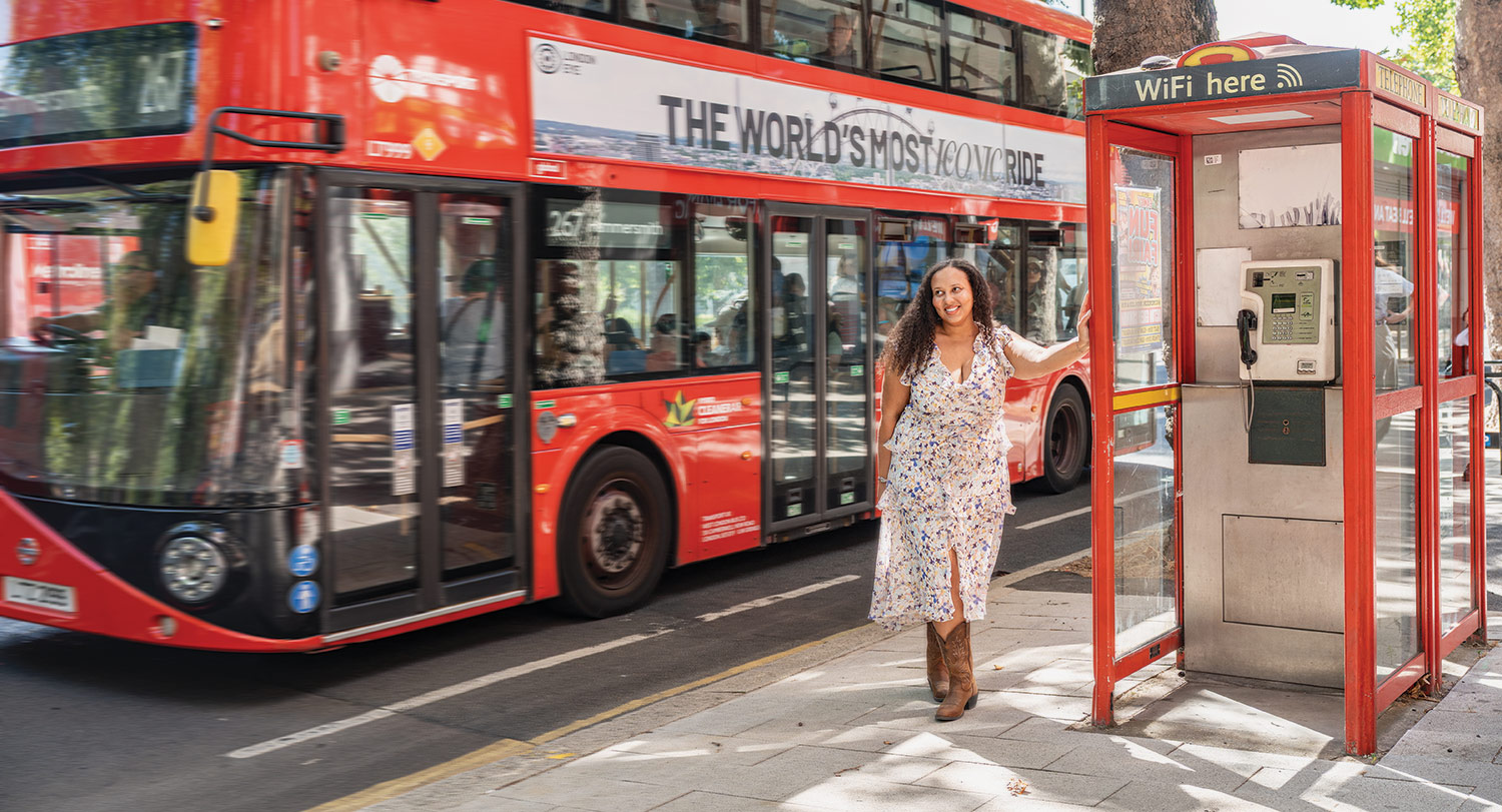 Visual communications alumna Morgan Epperson smiles for the camera beside a photo booth in London, England.