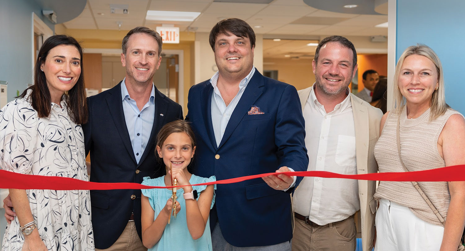 Group photo including Brittany and Becker Hall, daughter Josephine Hall, Hogs for the Cause cofounder Rene Louapre, treasurer Zandy Rainold and Lindsay Louapre