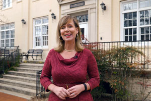 woman stands in front of a building