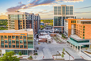 Rendering of a section of Greenville showing an outdoor patio surrounded by various downtown buildings.