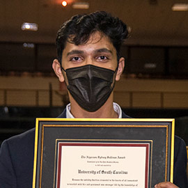 Adarsh Shidhaye holding his framed Sullivan Award.