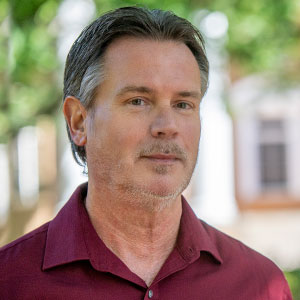 Mark Weist smiles in front of the psychology building.