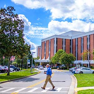 Man walks across VA hospital grounds on a sunny day