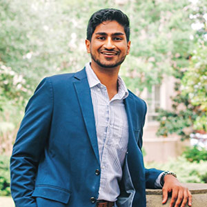 Jaimeen Shah stands on the Horseshoe Emily Ariail wearing a Carolina sweatshirt.