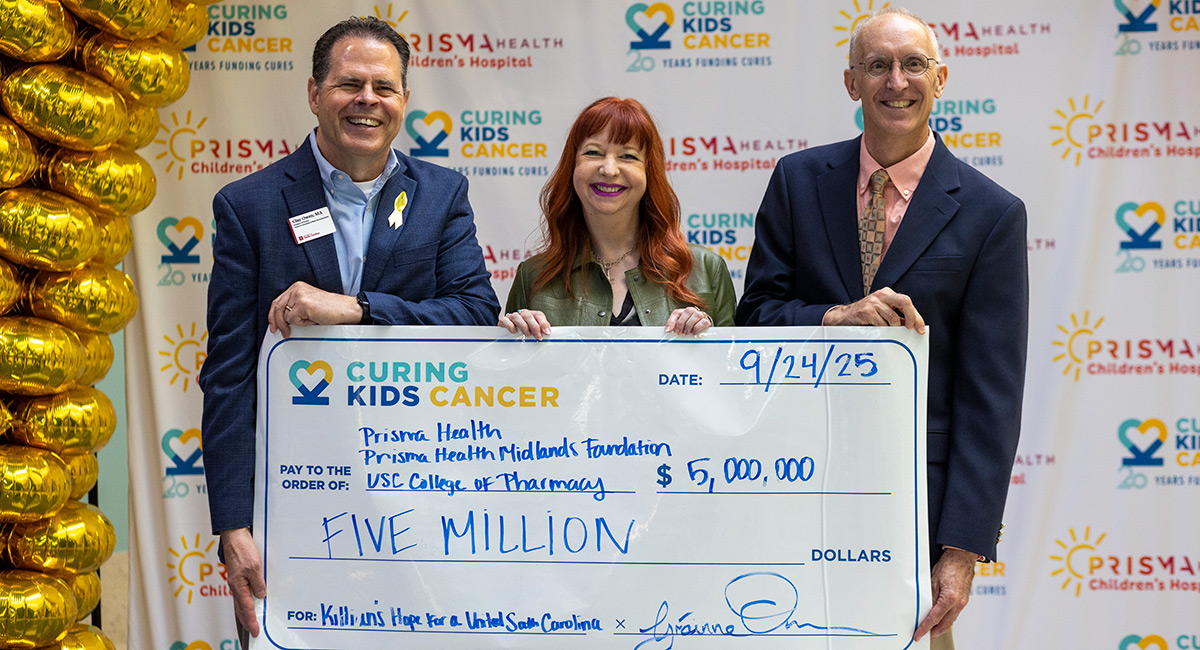 Curing Kids Cancer founders Clay and Grainne Owen present a check to Michael Wyatt from USC's College of Pharmacy